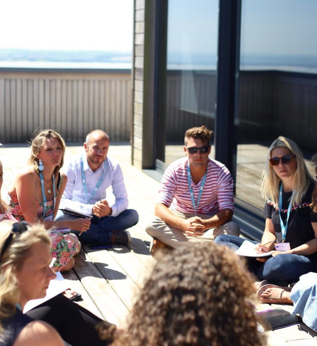 Mish is delivering a Retail course in the sunshine on a balcony.